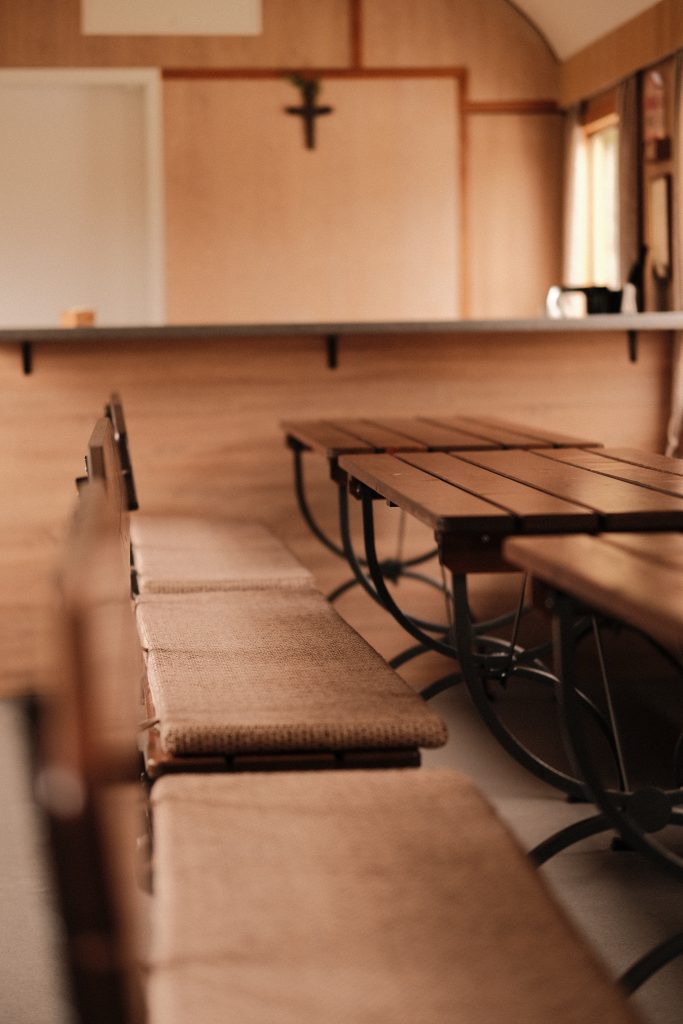 Drei lange Holztische mit jeweils zwei Sitzbänken